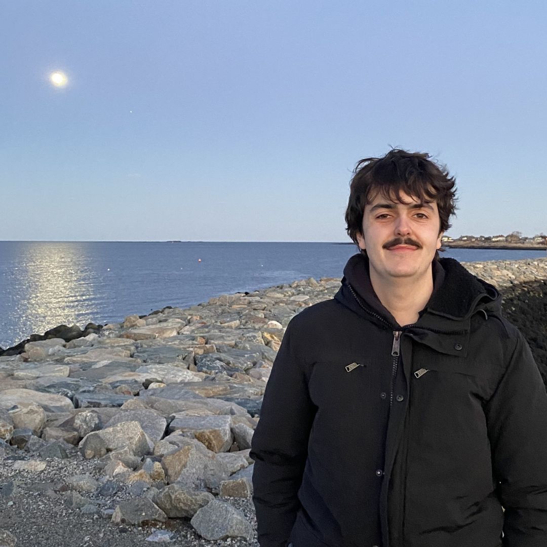 Paul stands along the water for his headshot